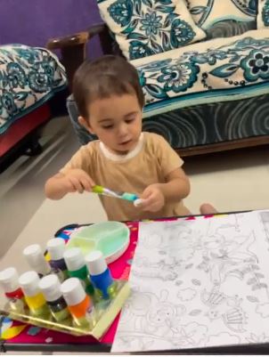 Kid is painting using brush